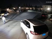 Nighttime cul-de-sac with parked cars and streetlights.