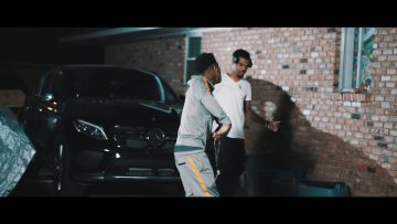 Two people talking by a parked Mercedes-Benz car.