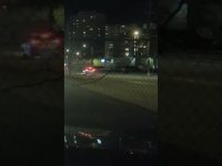 Nighttime city street with car headlights.