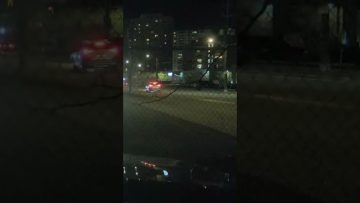 Nighttime city street with car headlights.