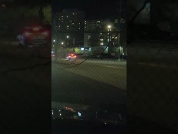 Nighttime city street with car headlights.