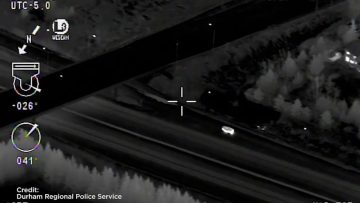 Nighttime aerial view, vehicle moving on road