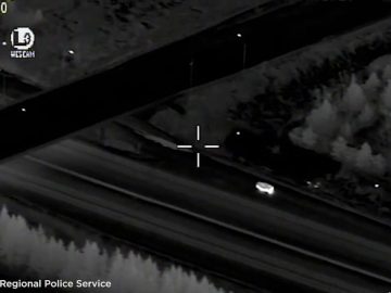 Nighttime aerial view, vehicle moving on road