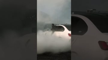 Car drifting with smoke on asphalt road.