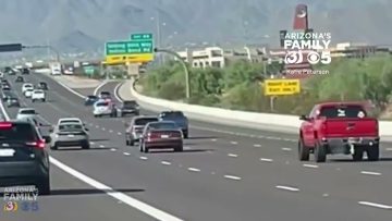 Cars driving on Arizona highway, daytime traffic scene.