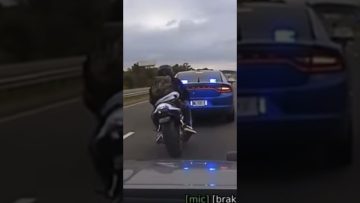 Motorcycle followed by police car on highway.