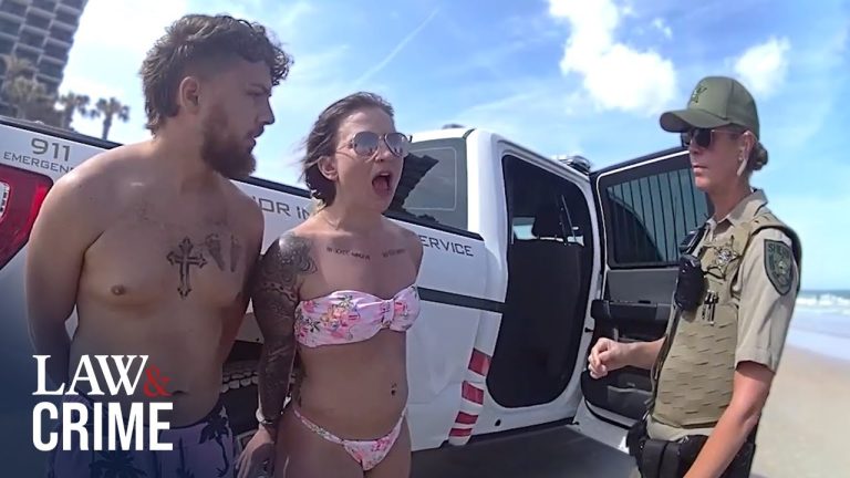 Beach arrest scene with officer and two individuals.