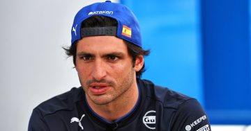 Man in blue cap with Spain flag patch.