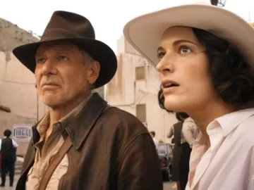 Two people in vintage clothing outdoors.