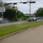 Car driving on suburban road, day scene.
