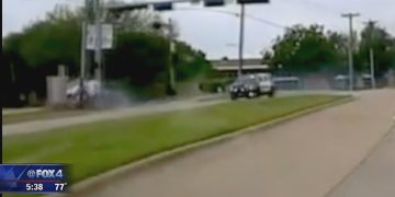 Car driving on suburban road, day scene.