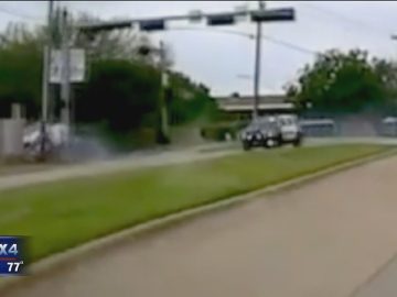 Car driving on suburban road, day scene.