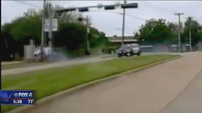 Car driving on suburban road, day scene.