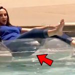 Woman on pool float with red arrow