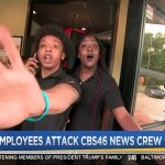 Employee confronts camera at restaurant entrance.