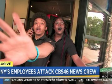Employee confronts camera at restaurant entrance.