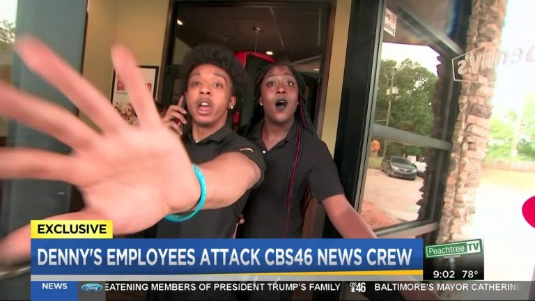Employee confronts camera at restaurant entrance.