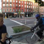 Cyclists paused at urban street intersection.