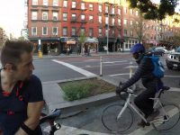 Cyclists paused at urban street intersection.