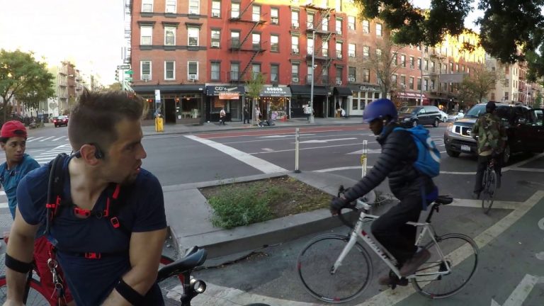 Cyclists paused at urban street intersection.