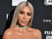Person at fashion event with jewelry and blonde hair.