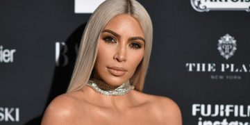 Person at fashion event with jewelry and blonde hair.