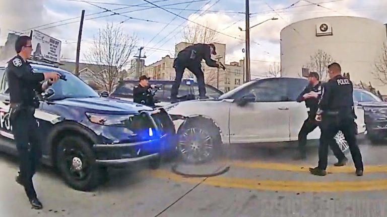 Police officers surrounding a car during a standoff.