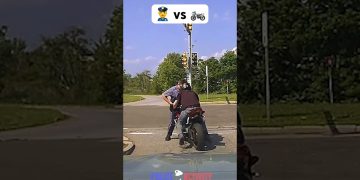 Police officer stops motorcyclist at intersection
