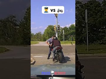 Police officer stops motorcyclist at intersection