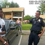 Police officer talking to man by car