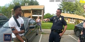 Police officer talking to man by car