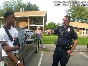 Police officer talking to man by car