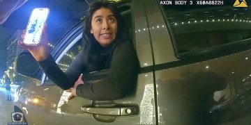 Woman leaning out car window at night