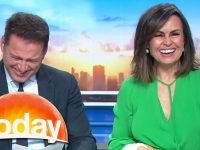 Two TV hosts laughing on morning show set.