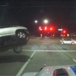 Car collision at night intersection, vehicle flipping over.