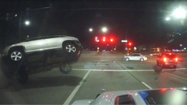 Car collision at night intersection, vehicle flipping over.