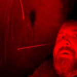 Person in red-lit environment, dramatic lighting.
