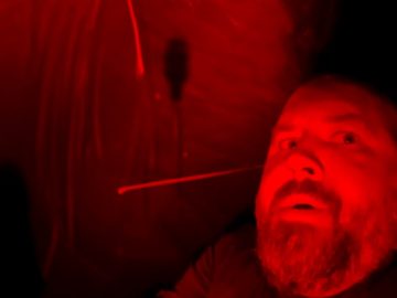 Person in red-lit environment, dramatic lighting.
