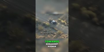 Police car driving off-road towards Rosamont Avenue.