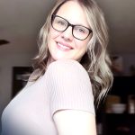 Smiling woman wearing glasses indoors.