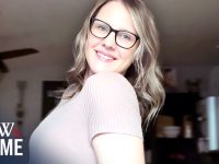 Smiling woman wearing glasses indoors.