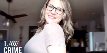 Smiling woman wearing glasses indoors.