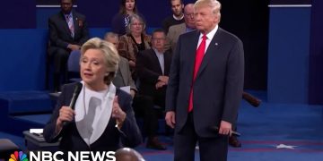 Politicians speaking during debate with audience behind them.