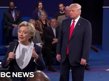 Politicians speaking during debate with audience behind them.