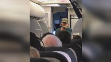 Person speaking on phone during flight.