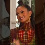 Smiling woman with geometric patterned outfit.