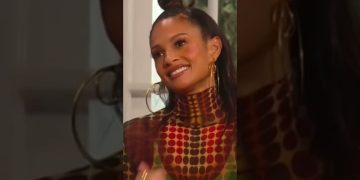 Smiling woman with geometric patterned outfit.
