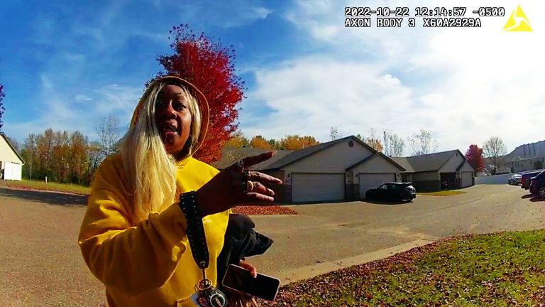Person in yellow sweater gesturing on suburban street.