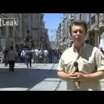 Reporter on busy city street with microphone