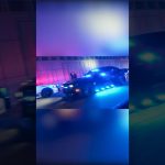 Police cars with flashing lights at night.